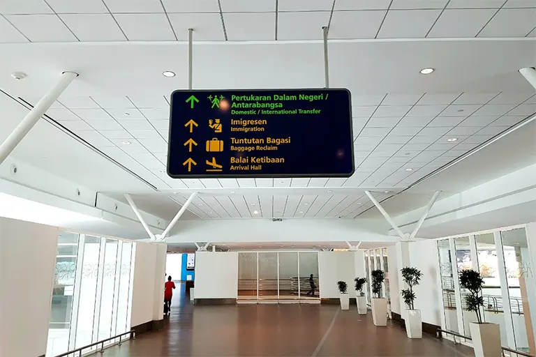 Observe overhead signboard and follow walkway to Transfer Hall