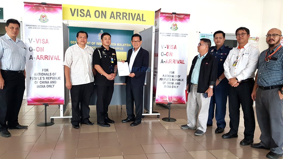 Assistant Minister of Tourism, Arts and Culture Datuk Lee Kim Shin holds a VoA form. From second left are Acting Miri Resident Abdul Aziz Mohamad Yusuf and Pellax